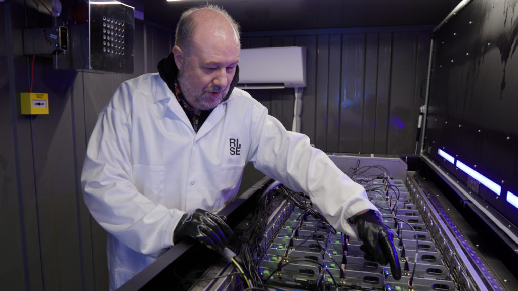 Jon Summers in the data centre container checking the servers cooled by liquid cooling.